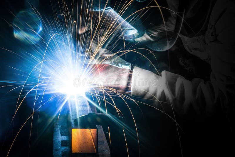 Employee welding steel in industry. Employee welding steel pieces in company royalty free stock images