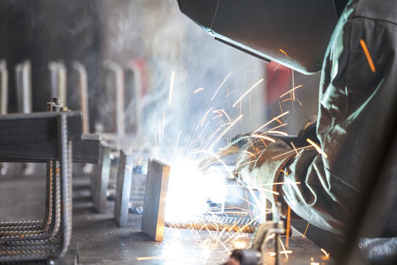 Industrial worker welding. Steel in the dark stock image